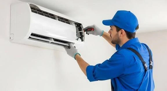 Technician servicing a wall-mounted air conditioning unit