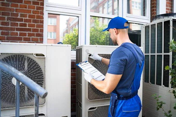 Technician completing an outdoor HVAC equipment inspection with a checklist